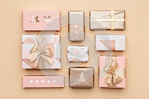 Gift wrapping composition. Beautiful nordic christmas gifts isolated on gold background. Pink and gold colored wrapped gift boxes.