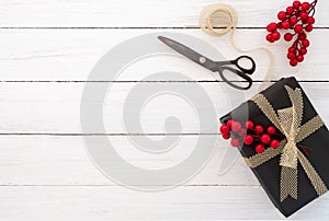 Gift wrapping. Hand crafted Christmas present gift box and tools on white wooden background. photo