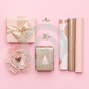 Gift wrapping. Pink and gold nordic christmas gifts isolated on pastel pink background.