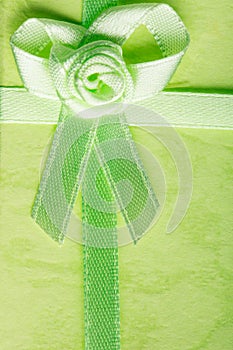 Giftbox closeup. Ribbon with bow on green background