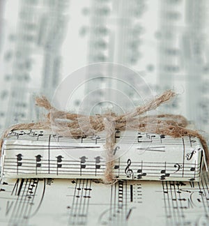 Giftbox on music sheet. A musical gift on notes background