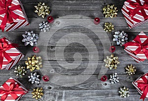 Giftboxes, burning candles and bows on vintage wooden planks for a merry Christmas or happy New Year holiday celebration concept