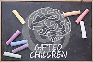 Gifted Children and education concept written on a blackboard in a classroom. Brain drawing and some colored chalk on a chalkboard photo