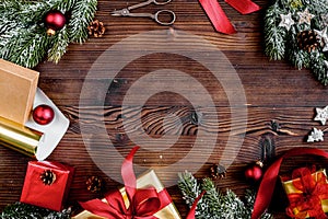 Gifts boxes with fir branches on wooden background top view