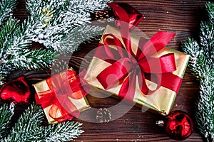 Gifts boxes with fir branches on wooden background top view