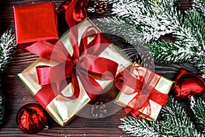 Gifts boxes with fir branches on wooden background top view