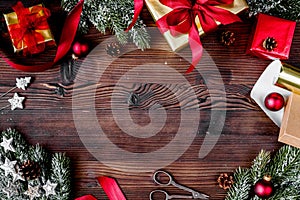 Gifts boxes with fir branches on wooden background top view