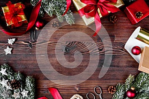 Gifts boxes with fir branches on wooden background top view