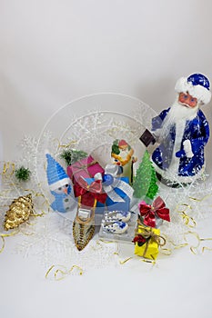 Gifts in boxes next to Santa Claus a snowman and Christmas tree close-up