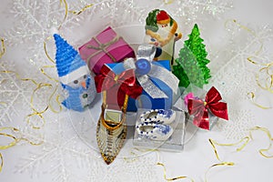 Gifts in boxes next to Santa Claus a snowman and a little ice-cream on a white background