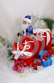 Gifts in boxes and red bags with Santa Claus on a white background