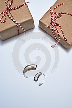 Gifts and digital hearing aids on white background
