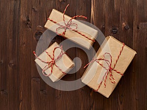 Gifts in kraft paper on a brown wooden background