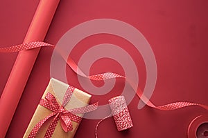 Gifts preparation, birthday and holidays gift giving, craft paper and ribbons for gift boxes on coral background as