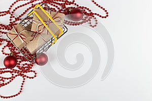 Gifts in a small shopping basket on a white background with Christmas decorations, concept, copy space