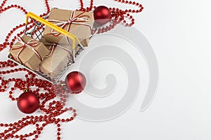 Gifts in a small shopping basket on a white background with Christmas decorations, concept, copy space