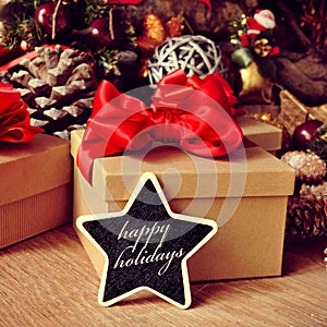 Gifts and text happy holidays in a star-shaped chalkboard