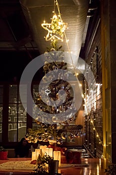 Gifts under Christmas tree in ambient living room with fireplace