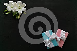 Gifts and white flowers for the holiday on a black background