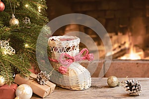 Gifts and wisker stocking under the Christmas tree in the room with a fireplace on Christmas eve