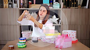 Gifts wrapping. attractive woman, designer of gifts and decorations shows training online, records videoblog, webinar