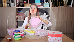 Gifts wrapping. attractive woman, designer of gifts and decorations shows training online, records videoblog, webinar