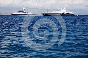Gigantic big and large luxury yacht with sail boat and helicopter landing place on bord.