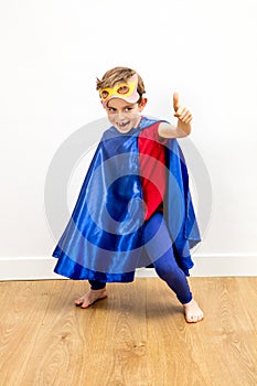 Giggling superhero boy with thumbs up pretending super exciting power