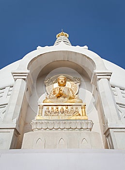 Gilded bas-relief of Buddha in a pose of a dharmachakra mudra.