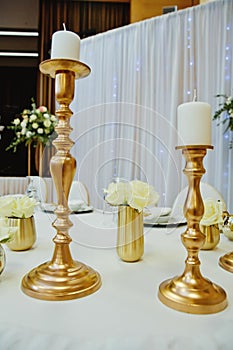 Gilded candlestick on a festive wedding table. Elegance wedding decor