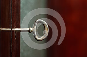 Gilded key in the lock hole of a home cabinet