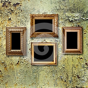 Gilded wooden frames for pictures on rusty metallic wall