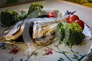 Gilt-head bream fish grilled with tomato and broccoli
