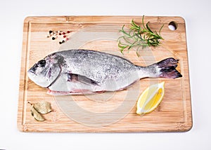 Gilt-headed bream and spices on a chopping board.