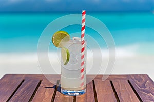 Gin Rickey cocktail on wooden table ocean background at the beach