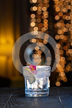 Gin tonic cocktail in front of a brown gold background. Cocktail drink in bar.