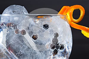 Gin tonic cocktail macro closeup with juniper berries