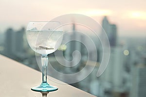 Gin tonic cocktail on table in rooftop bar photo