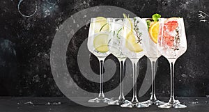 Gin and tonic cocktails set. Trendy Alcoholic drinks with lime, lemon, grapefruit, orange, cucumber, soda and spicy herbs in wine