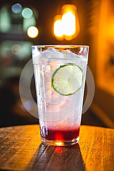 Gin Tonic with strawberry syrup and lemon slice photo