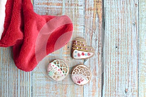 Gingebread cookies on a wood table with santa sock by the side