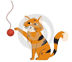 Ginger cat plays with a ball of thread. Lovely kitten. Funny friendly domestic animal, pet.