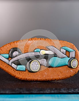 Ginger and delicious gingerbread in the form of a formula one car on a glossy board