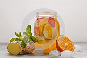 Ginger fruity ice tea with mint in a glass jar, white background