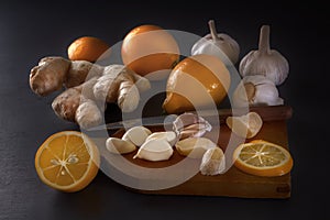 Ginger, garlic and lemon - a means to protect against viral infection and colds on a dark table.