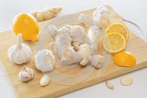 Ginger, garlic and lemon - a means to protect against viral infection and colds on a light wooden table.
