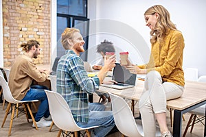 Ginger guy talking to a blone female colleague in the office