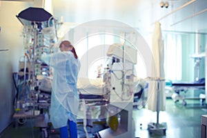 Ginger-haired female doctor working with patient in the ICU, unfocused background photo