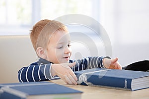 Ginger-haired little boy with encyclopedia smiling