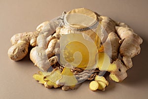 Ginger jam in small square jar and fresh ginger